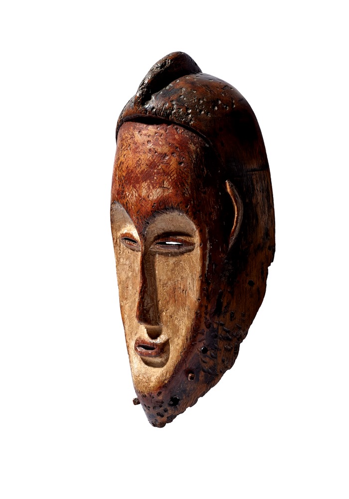 A wooden mask with pigments and covered with kaolin
